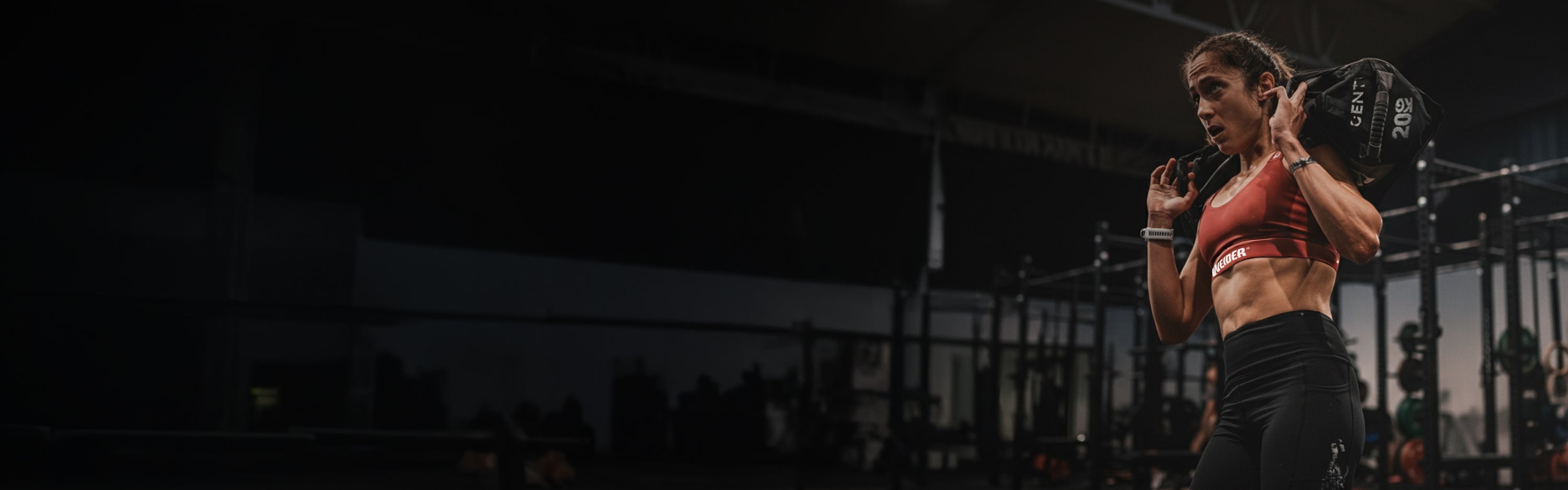 Atleta Weider entrenando con un saco de peso en el gimnasio